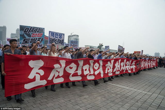 Những người tuần hành vừa hô khẩu hiệu vừa giơ nắm tay lên cao để thể hiện tinh thần quyết tâm của đất nước Triều Tiên (Ảnh: AFP)