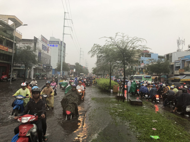 Hình ảnh quen thuộc của người dân TPHCM sau mỗi trận mưa lớn