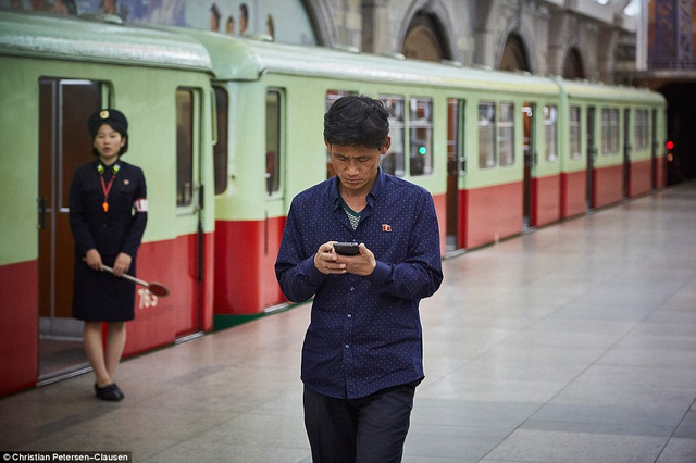 Người đàn ông chăm chú vào màn hình điện thoại trong một trạm tàu điện ngầm ở Bình Nhưỡng