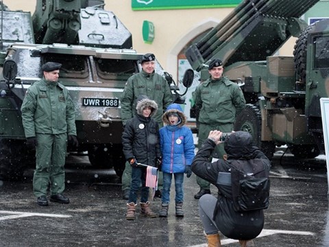 Hai em bé chụp ảnh với các binh sĩ của quân đội Ba Lan tại sự kiện