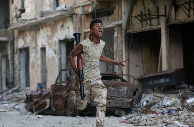 Một thành viên của Quân Giải phóng Lybia mang vũ khí trong cuộc đụng độ với các phiến quân Hồi giáo ở Benghazi, Libya ngày 9/11.