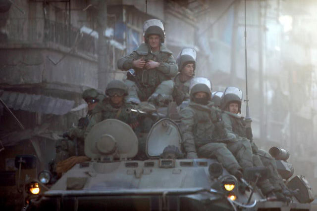 Các binh sĩ Nga ngồi trên xe bọc thép tuần tra đường phố Aleppo trong cuộc chiến chống khủng bố tại “chảo lửa” Syria.