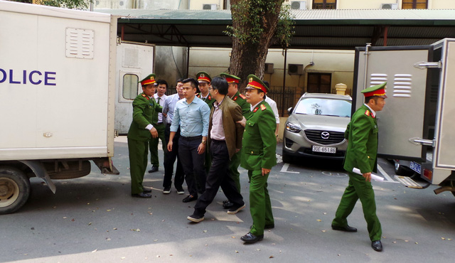 Giang Kim Đạt (áo khoác nâu) bị dẫn giải đến nghe tuyên án chiều 22/2.