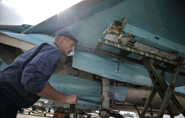 Một kỹ thuật viên kiểm tra máy bay ném bom đa nhiệm Su-34 tại căn cứ Hmeymim