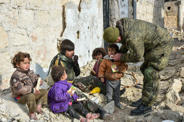 Các kỹ sư quân sự thuộc trung tâm rà phá bom mìn của Nga chăm sóc cho một bé trai ở Aleppo, Syria