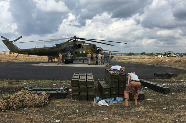 Các kỹ thuật viên quân sự đứng gần một trực thăng tấn công Mi-24 của Nga tại căn cứ Hmeymim
