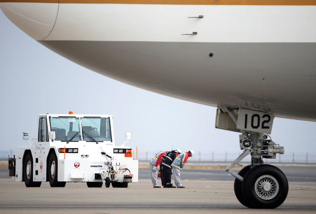   Các nhân viên sân bay Haneda cúi chào trước khi máy bay của Nhà vua Nhật Bản cất cánh. (Ảnh: Reuters)  