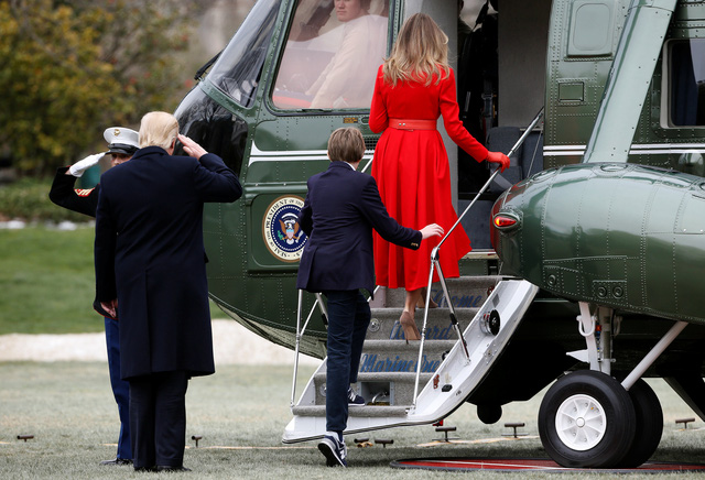 Sau khi rời Nhà Trắng, gia đình ông Trump lên trực thăng Marine One, máy bay đặc biệt được thiết kế riêng để phục vụ cho nhu cầu đi lại trong phạm vi ngắn của tổng thống Mỹ, tới căn cứ không quân Andrews ở bang Maryland. Trong ảnh: Tổng thống Trump chào một sĩ quan quân đội trước khi bước lên trực thăng Marine One.