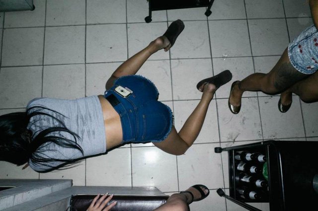 Một cô gái đang bò trên nền đất dơ bẩn trong một nhà chứa ở Bangkok