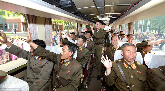 “Các tuyến đường tại thủ đô Bình Nhưỡng tràn ngập không khí tưng bừng của một ngày hội để chào đón các nhà khoa học của nền quốc phòng”, hãng thông tấn quốc gia Triều Tiên (KCNA) đưa tin. Trong ảnh: Các nhà khoa học vẫy tay chào người dân ở thủ đô Bình Nhưỡng (Ảnh: AFP)
