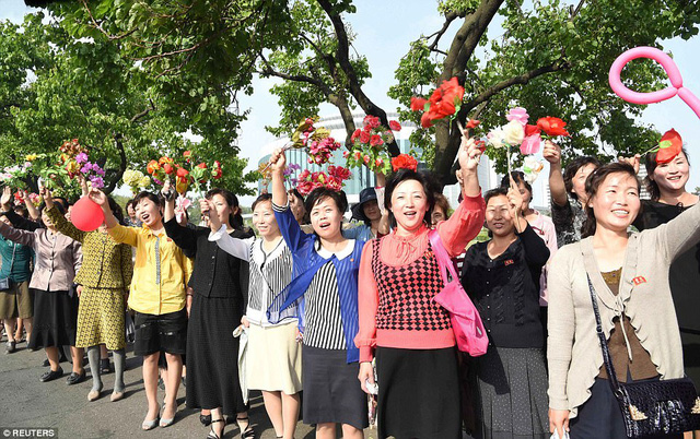 Sự hồ hởi, vui tươi hiện rõ trên gương mặt của những người dân Triều Tiên khi đón đoàn các nhà khoa học - những người góp công sức vào việc phát triển tên lửa Hwasong-12. (Ảnh: Reuters)