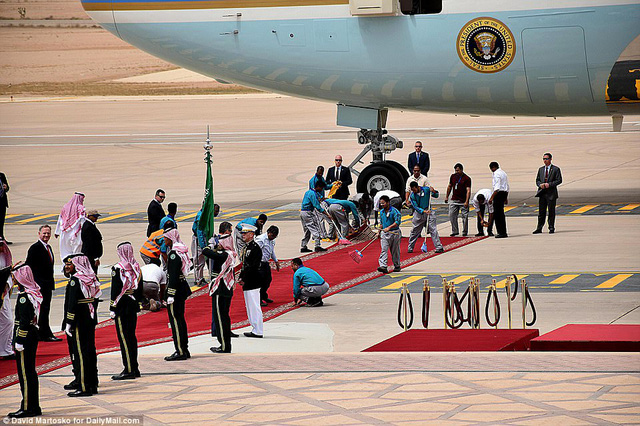   Các nhân viên tất bật chuẩn bị thảm đỏ trước khi nhà lãnh đạo Mỹ bước xuống từ chuyên cơ.  