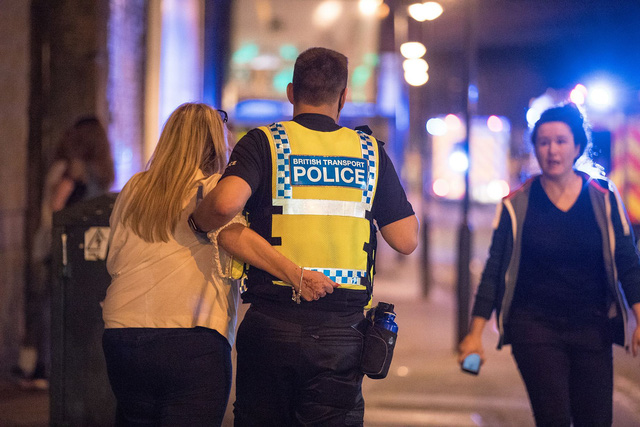 Cảnh sát dìu một nạn nhân ra khỏi nhà thi đấu Manchester (Ảnh: Telegraph)