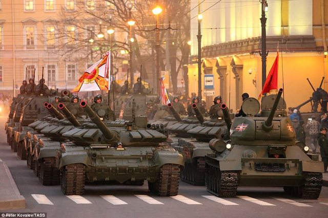 Ngày 9/5 tới, Nga sẽ tổ chức lễ duyệt binh kỷ niệm 72 năm Ngày Chiến thắng phát-xít Đức tại Quảng trường Đỏ ở thủ đô Mosocw. Khoảng 10.000 quân nhân, 114 phương tiện bọc thép cùng hàng chục máy bay chiến đấu và trực thăng dự kiến sẽ tham gia lễ duyệt binh hoành tráng năm nay. Trong ảnh: Đoàn xe tăng T-72B3 (trái) và T-34-85 (phải) luyện tập diễu hành trên quảng trường Cung điện ở thành phố St. Petersburg hôm 6/5 chuẩn bị cho lễ duyệt binh mừng Ngày Chiến thắng.