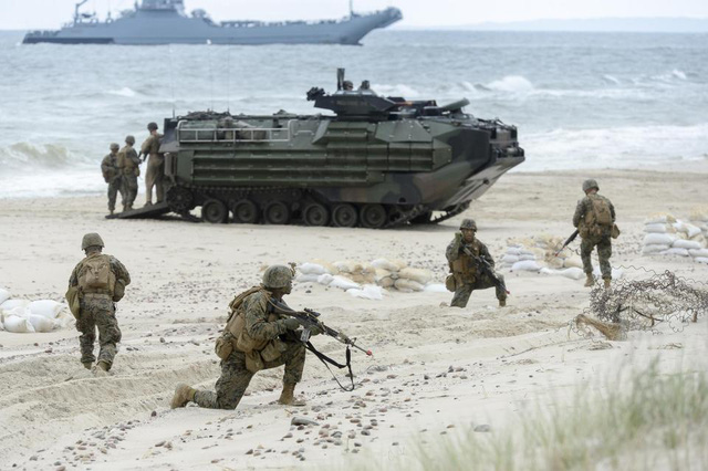 Các binh sĩ phối hợp nhuần nhuyễn với xe quân sự trong một bài tập tấn công đổ bộ (Ảnh: REX)