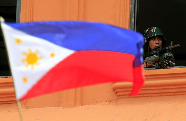 Quân đội Philippines cho biết có 40 tay súng khủng bố nước ngoài đang cố thủ tại nước này, trong đó có khoảng 20 người Indonesia, còn lại là người Malaysia, Ả-rập Xê-út, Yemen, Pakistan… Số lượng này dự kiến sẽ tiếp tục tăng lên trong vài tháng tới khi cuộc xung đột tại Marawi ngày càng diễn biến phức tạp. Trong ảnh: Binh sĩ Philippines đứng gác trong một căn nhà tại thành phố Marawi.