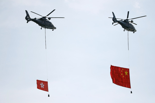 Các trực thăng của đội nghi lễ mang quốc kỳ Trung Quốc và khu kỳ Hong Kong bay lượn vòng trên Quảng trường Kim Tử Kinh tại lễ kỷ niệm 20 năm Hong Kong được Anh trao trả về Trung Quốc.