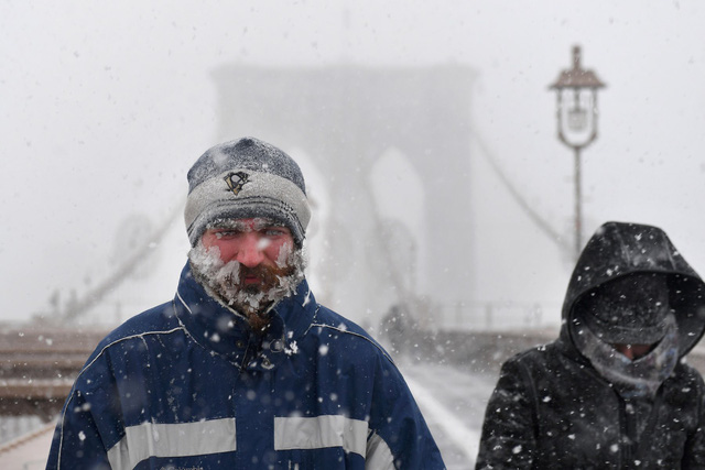 Truyền thông Mỹ đưa tin một người đàn ông 64 tuổi ở bang Ohio đã bị chết cóng ngay trước hiên nhà khi nhiệt độ giảm sâu hôm 3/1. Trong ảnh: Tuyết đóng băng trên gương mặt một người đi bộ tại cây cầu Brooklyn ở thành phố New York. (Ảnh: Reuters)