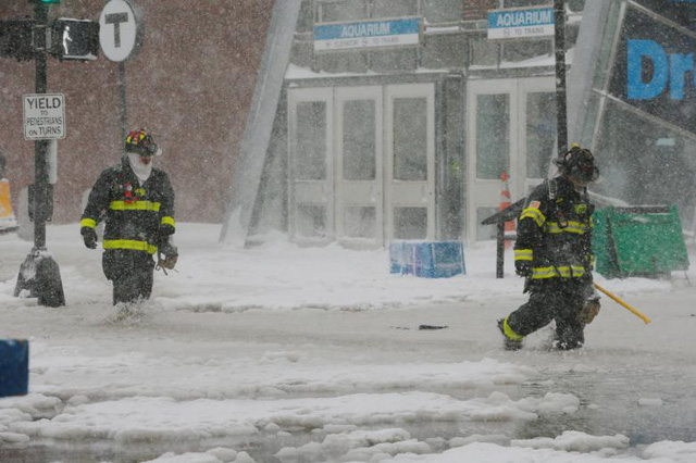 Hiện tượng tuyết rơi dày đã ảnh hưởng tới cuộc sống của hàng triệu người dân Mỹ. Các nhà chức trách và người dân ở khu vực bờ Đông nước Mỹ đang nỗ lực dọn tuyết để mở đường cho xe đi lại. Trong ảnh: Lính cứu hỏa bước qua con đường ngập trong nước và tuyết ở Boston. (Ảnh: Reuters)