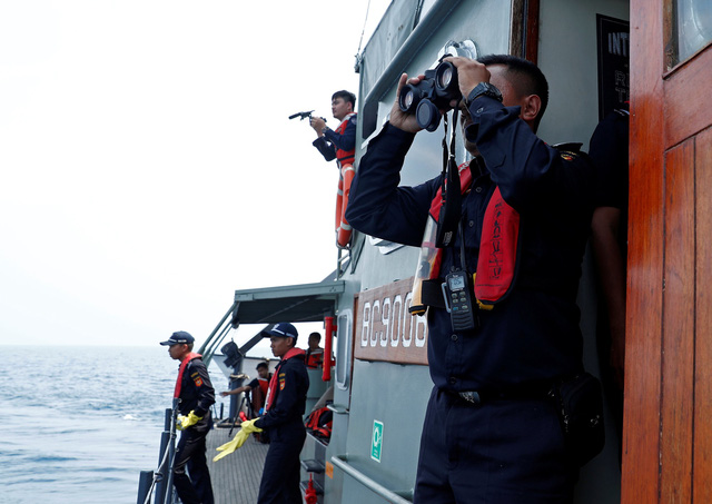   Đội tìm kiếm cứu hộ dùng ống nhòm quan sát vùng biển tìm kiếm máy bay gặp nạn.  