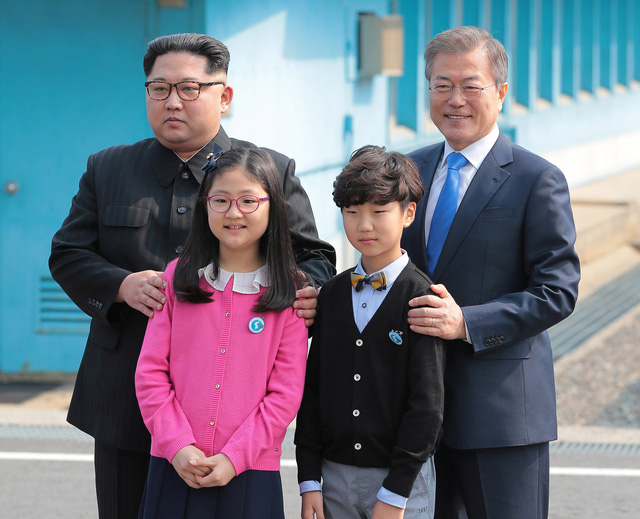 Ông Kim Jong-un và ông Moon Jae-in cùng nhau chụp ảnh với hai em nhỏ Hàn Quốc tặng hoa cho nhà lãnh đạo Triều Tiên. Đây là hai học sinh tại trường tiểu học ở làng Daeseongdong - ngôi làng duy nhất tại khu phi quân sự liên Triều.