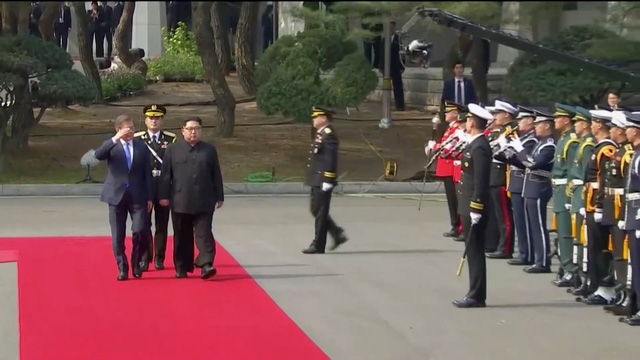 Tổng thống Moon Jae-in giơ tay chào khi duyệt đội danh dự cùng ông Kim Jong-un.