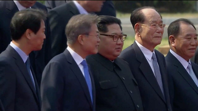 Ông Kim Jong-un và ông Moon Jae-in đứng cạnh nhau trong lúc chụp ảnh lưu niệm.