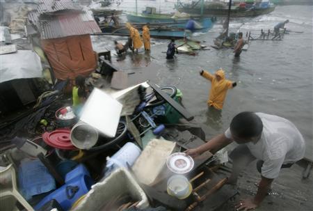 Người dân vùng duyên hải sơ tán đồ đạc tới khu vực cao khi cơn bão tiến gần tới Navostos, Manila sáng sớm qua