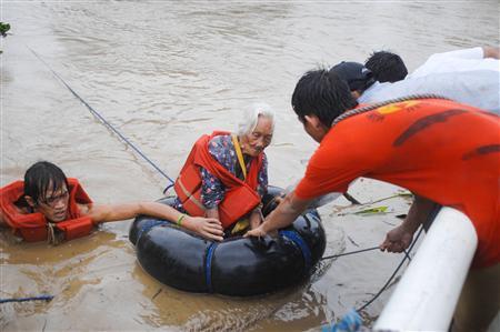 Nhóm cứu hộ đưa một cụ bà khỏi dòng nước trên sông Jaro, gần thành phố Iloilo, miền trung Phillippines sau bão