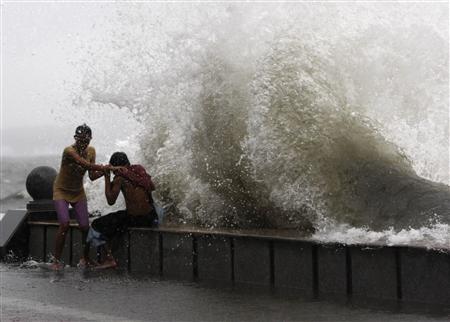 Một cặp tình nhân vẫn đùa nghịch trong sóng lớn ở vịnh Manila trong cơn bão Fengshen
