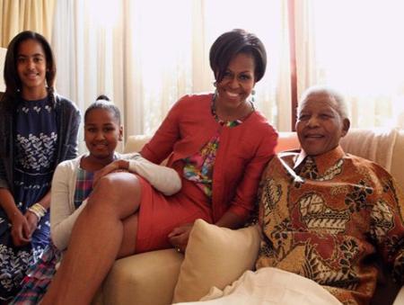 This file photo provided June 21, 2011 by the Nelson Mandela Foundation, shows US First Lady Michelle Obama center, accompanied by her daughters, Malia, left and Sasha, meet former South African President Nelson Mandela, at this home in Houghton, South Africa. (AP Photo/ Debbie Yazbek, Nelson Mandela Foundation, File)
