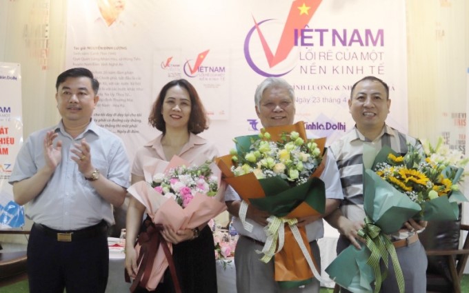 The Editor-in-Chief of Economic and Urban Newspaper presents flowers to representatives of Vietnam News Publishing House, author Nguyen Dinh Luong, and representatives of AZ Invest and Consultant Service Joint Stock Company. Photo: Quang Tan.