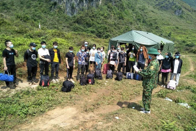 Cán bộ Đồn Biên phòng Ngọc Côn lấy lời khai các công dân Việt Nam nhập cảnh trái phép từ Trung Quốc vào Việt Nam ngày 1/5. Ảnh: T.L.