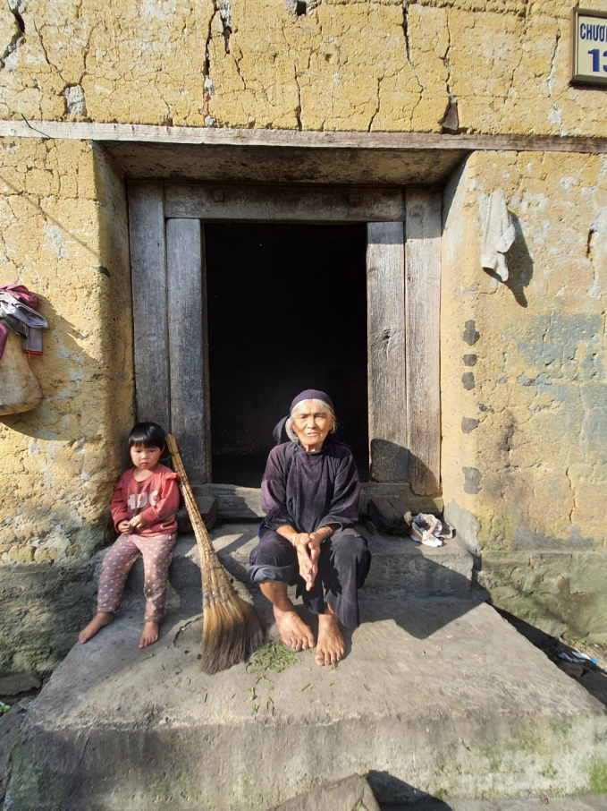 Hai bà cháu ở Lao Chải (Y Tý) trước thềm căn nhà cổ xây bằng đất hơn 100 năm tuổi. Ảnh: H.Đ.