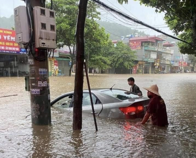 Mưa lớn, người dân không kịp di chuyển xe tới nơi an toàn. Ảnh: C.T.