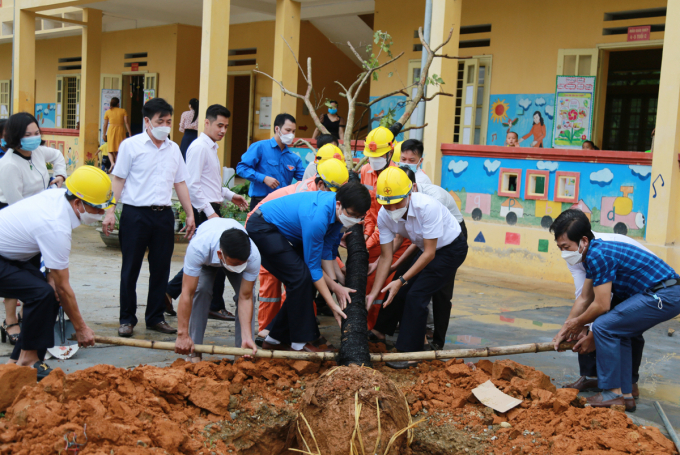 Cán bộ, người lao động điện lực Lào Cai trồng cây và đổ bê tông sân trường cho học sinh vùng cao. Ảnh: Hải Đăng.