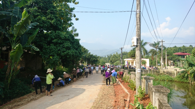 Người dân tham gia làm đường, trồng hoa tạo cảnh quan môi trường sống đẹp, gần gũi thiên nhiên. Ảnh: T.L