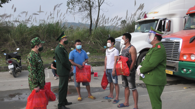 Lực lượng chức năng tại cửa khẩu Kim Thành tặng bánh chưng Tết cho lái xe nông sản. Ảnh: T.D