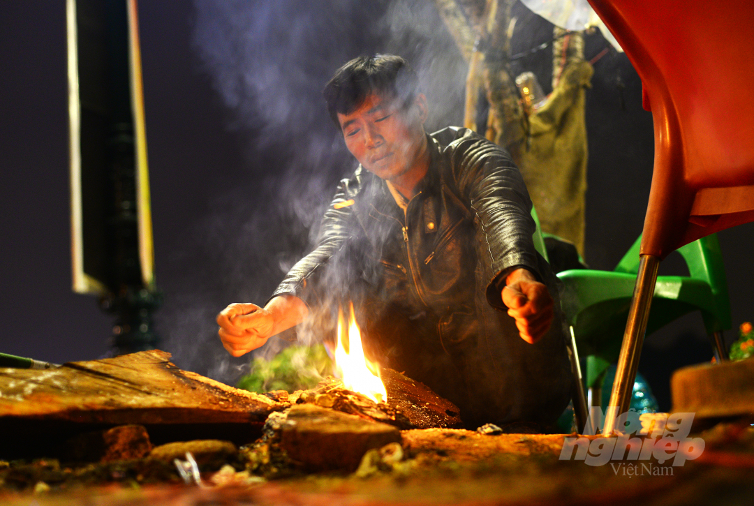 Anh Đinh Văn Phương đốt lửa để chống chọi lại với sương lạnh đêm Đà Lạt. Năm nay, anh Phương nhập hàng trăm gốc bưởi, hoa ngũ sắc, hoa đào từ Hà Nội về Đà Lạt bán.