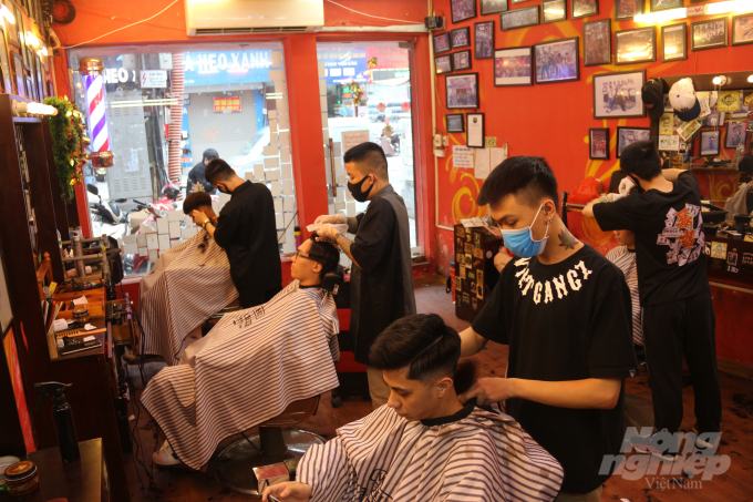 Sau 3 tuần thực hiện cách ly xã hội ở nhà, nhiều người dân Hà Nội đã đến các tiệm cắt tóc để làm đẹp. Một tiệm cắt tóc trên đường Đội Cấn, Ba Đình luôn trong tình trạng không một ghế trống từ sáng đến tận chiều tối. Ảnh: Phạm Hiếu.