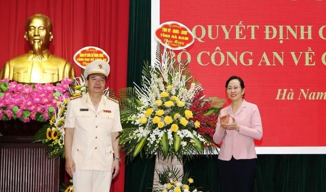 Đại tá Nguyễn Văn Trung nhận hoa chúc mừng từ Bí thư Tỉnh ủy Hà Nam Lê Thị Thủy. Ảnh: VGP.