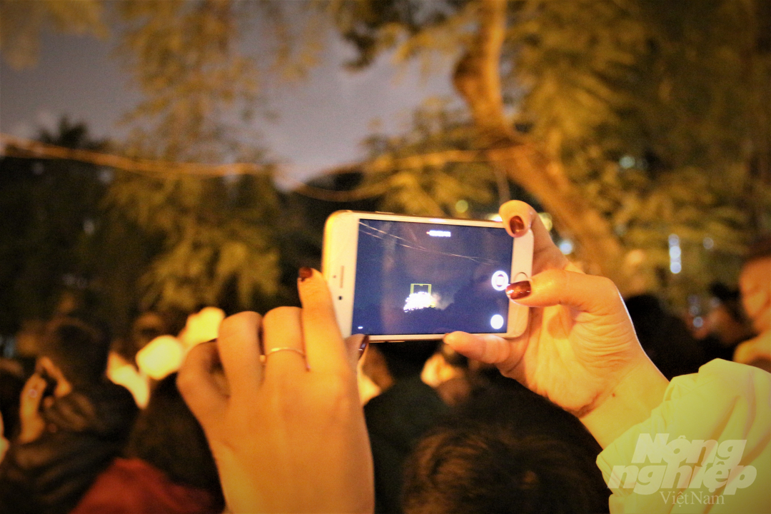 Nhiều người dân đã lưu lại khoảnh khắc bắn pháo hoa đón năm mới bằng chiếc điện thoại để gửi cho người thân.