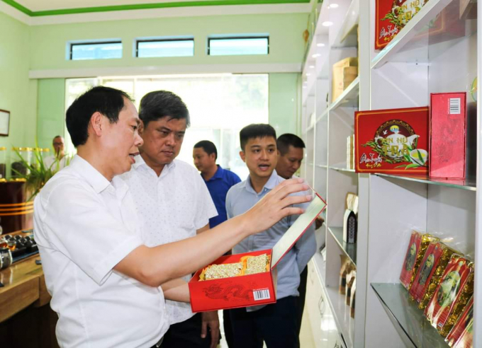 Trưởng phòng NN-PTNT huyện Hoàng Su Phì Lý Chòi Nhàn giới thiệu với ông Trần Thanh Nam sản phẩm OCOP của huyện. Ảnh: FHT.
