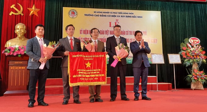 Thứ trưởng Bộ NN-PTNT Lê Quốc Doanh thừa ủy quyền của Thủ tướng Chính phủ trao Cờ thi đua xuất sắc cho Ban giám hiệu Trường Cao đẳng Cơ điện và Xây dựng Bắc Ninh. Ảnh: Nguyên Huân.