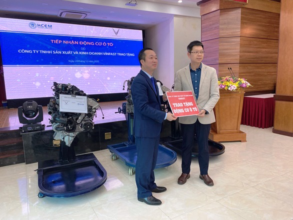 TS Đồng Văn Ngọc, Hiệu trưởng HCEM (bên trái) nhận 3 động cơ ô tô do phía Vinfast trao tặng. Ảnh: Ngọc Diệp.