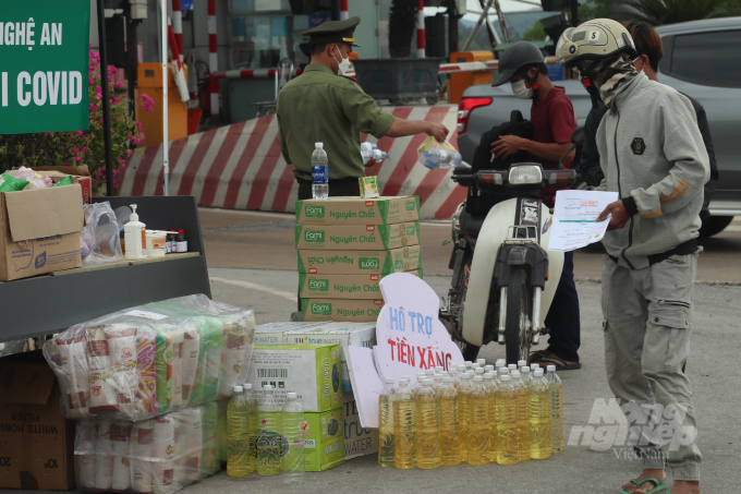 Tại chân cầu Bến Thủy (Nghệ An), các lực lượng trực chốt đã tiếp tế thức ăn, nước uống và cả miễn phí xăng xe cho đồng bào hồi hương. Ảnh: Doãn Hòa