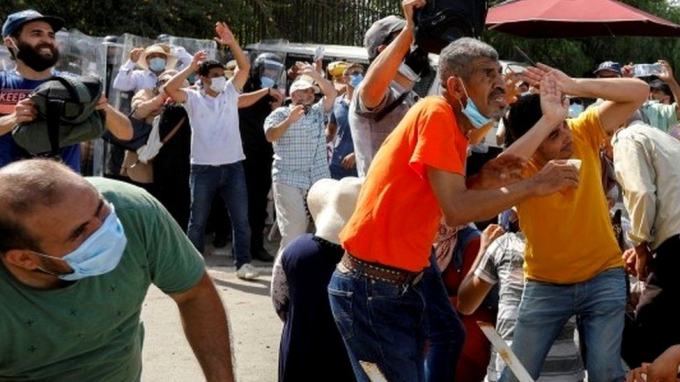 Người dân xuống đường ở thủ đô Tunis và xô xát, sáng 26/7. Ảnh: Reuters.