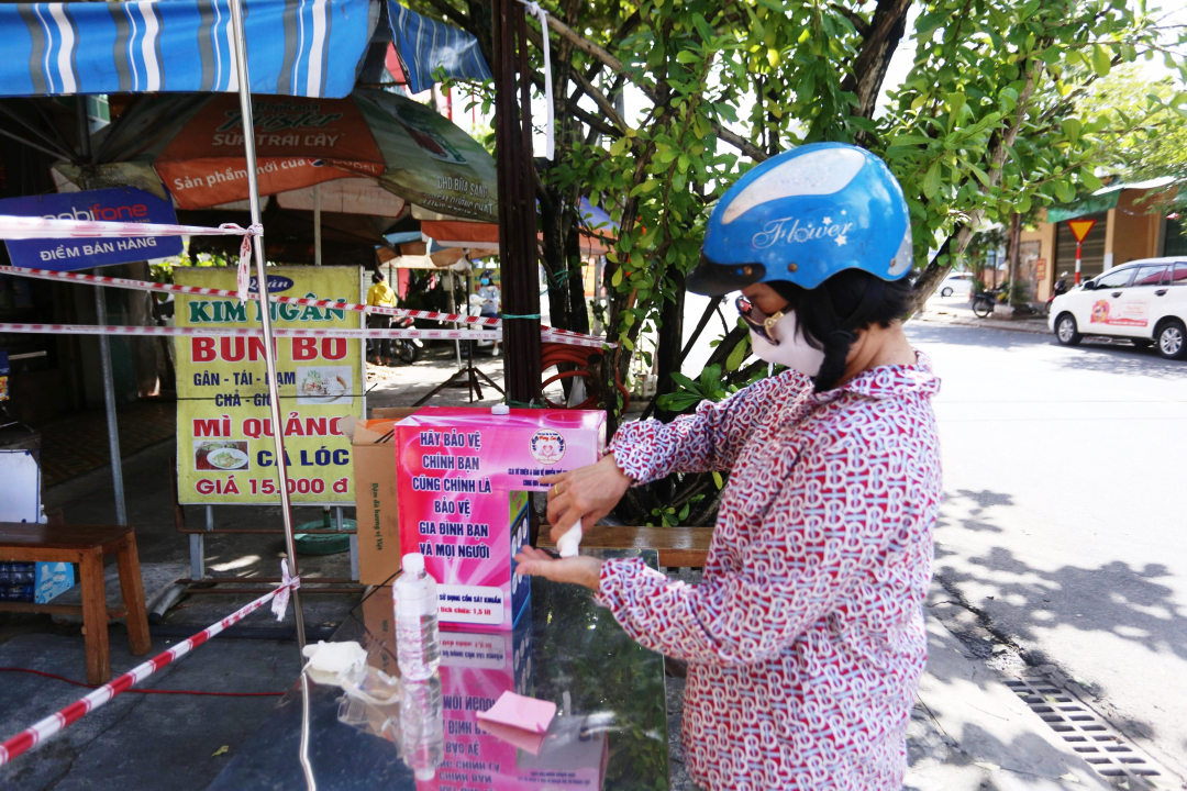 Phía bên ngoài 'Siêu thị' được bố trí rào chắn cẩn thận, có điểm rửa tay sát khuẩn và đo thân nhiệt cho những người dân đến lấy thực phẩm. Ảnh: L.K.