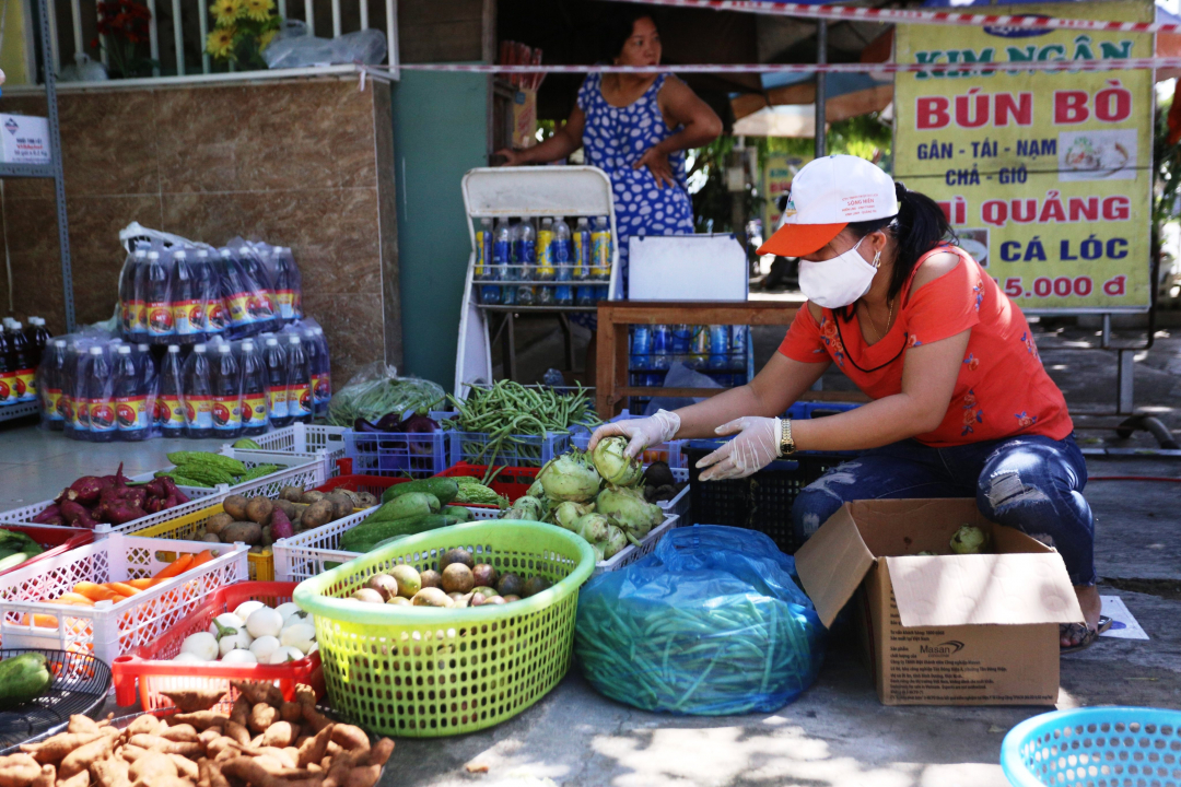 Thực phẩm được chuyển đến sẽ được tình nguyện viên kiểm tra, vứt bỏ những phần bị hỏng, sau đó mới được xếp vào các giỏ hàng. Ảnh: L.K.