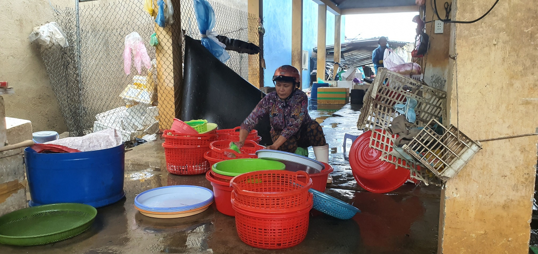 Người dân trong chợ cá Bình Châu dọn rửa đồ đạc bị ảnh hưởng do bão. Ảnh: L.K.